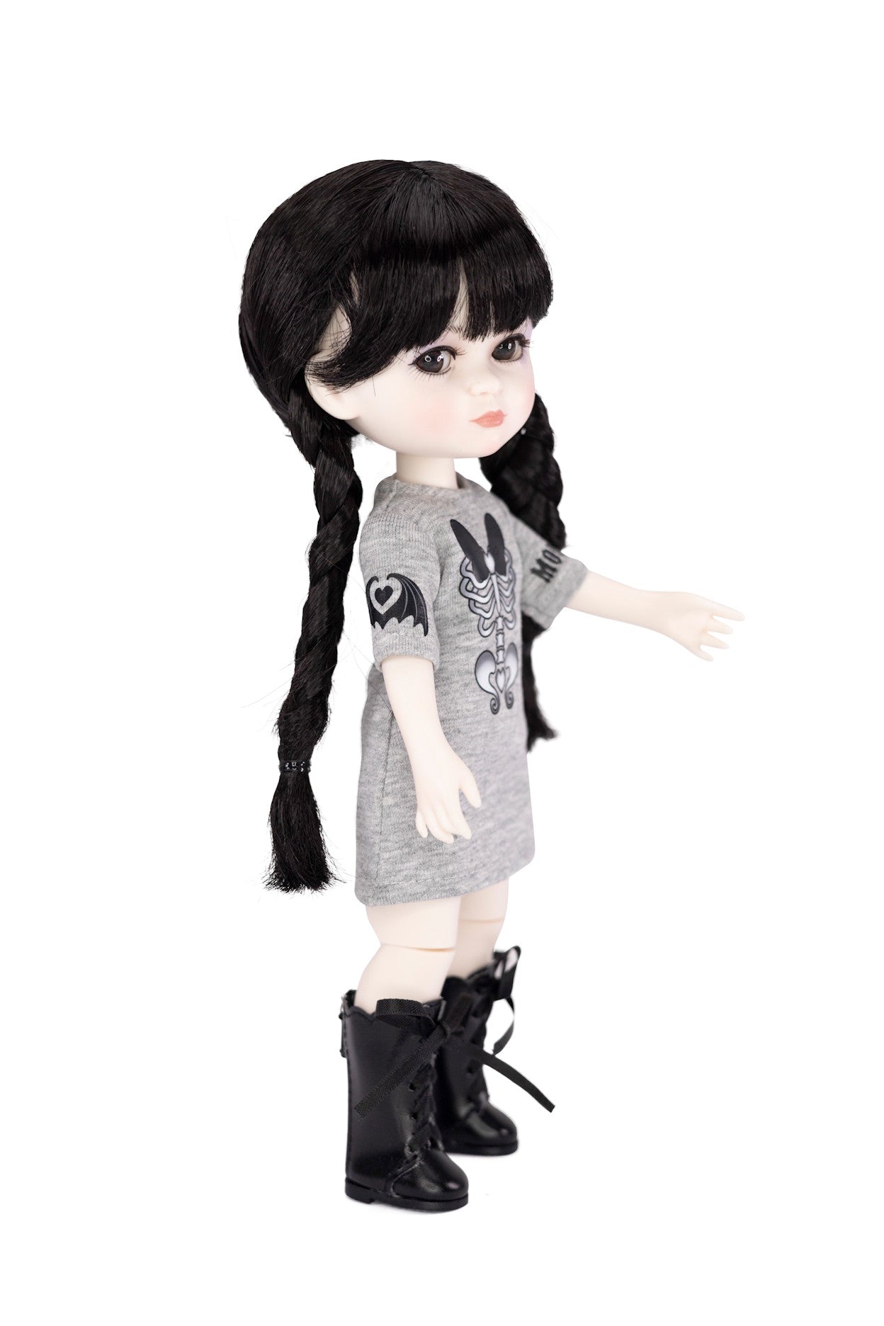 Doll with black hair styled in pigtails, wearing a gray dress with black boots on a white background