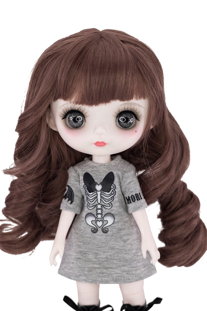 Doll with long brown hair wearing a gray dress with a skeleton design on a white background
