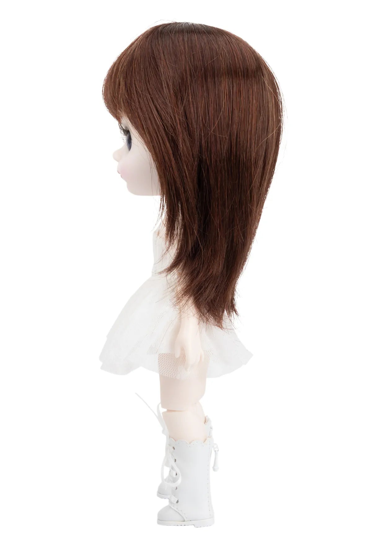 Doll with brown hair and white outfit on a white background