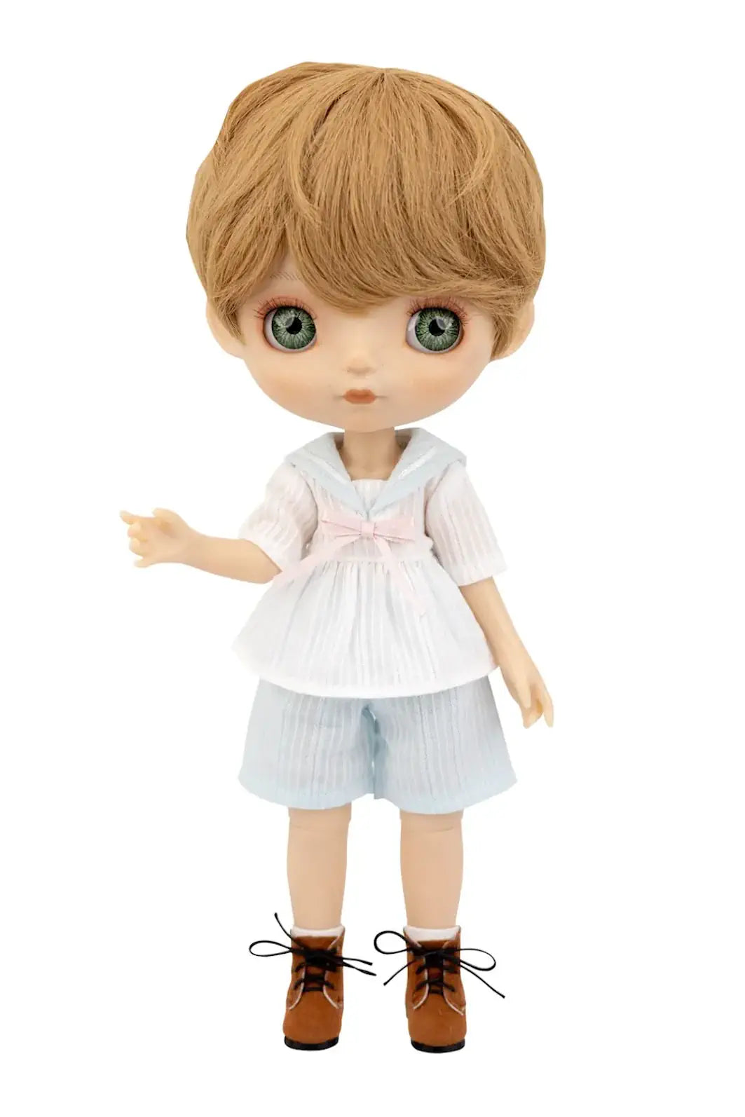 A Mori Lolli doll with light brown hair and large green eyes, wearing a white short-sleeve top with a pink bow, light blue shorts, and brown shoes, shown against a plain white background.