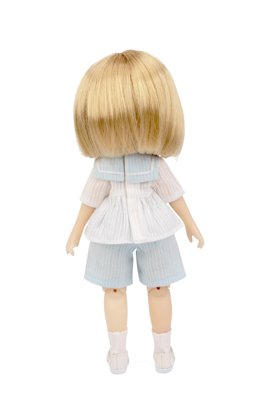 A blonde doll viewed from the back, wearing a white ruffled short-sleeve top, light blue striped shorts, white socks, and white shoes against a plain white background.