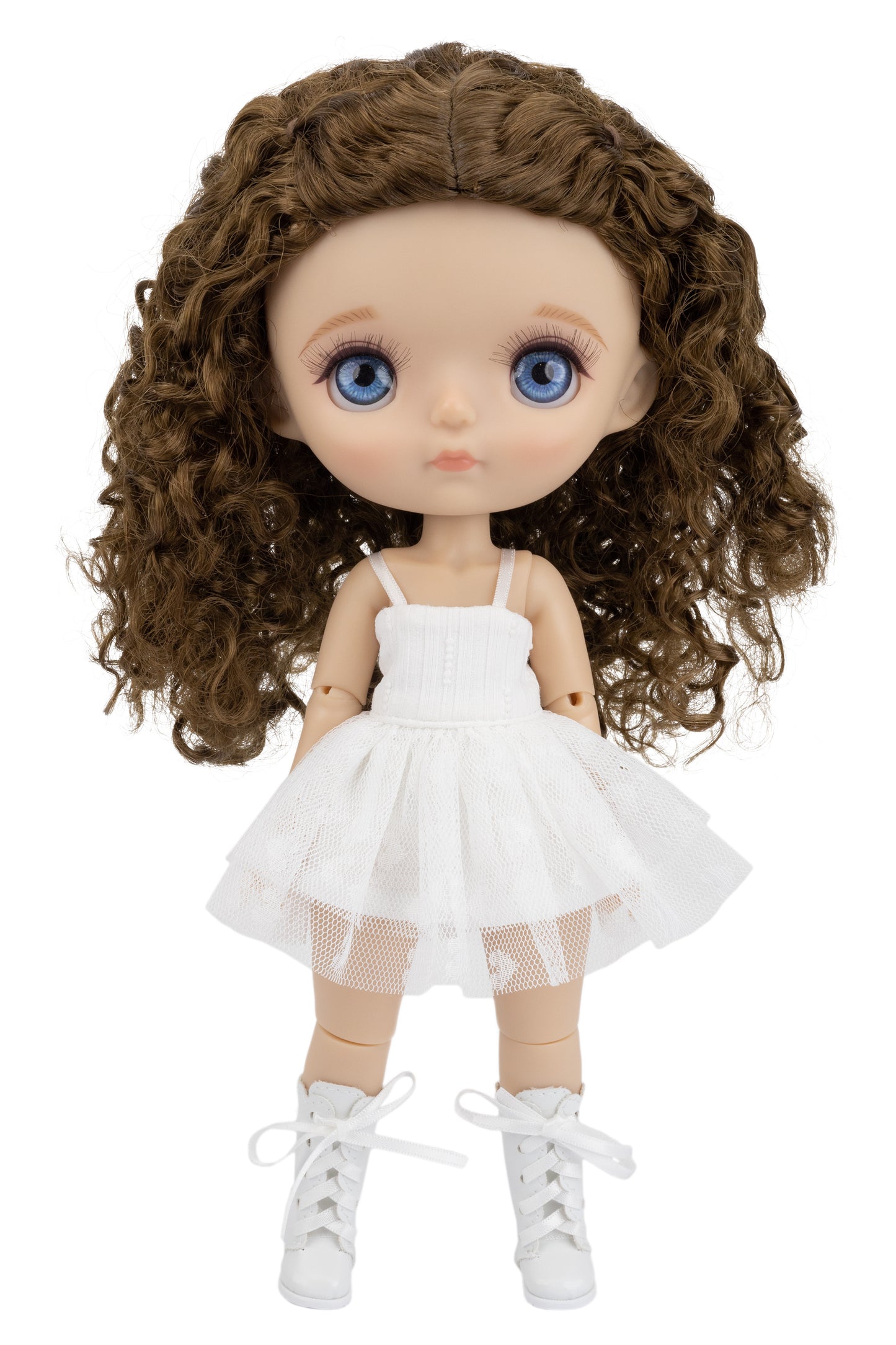 Doll with curly brown hair wearing a white dress on a white background